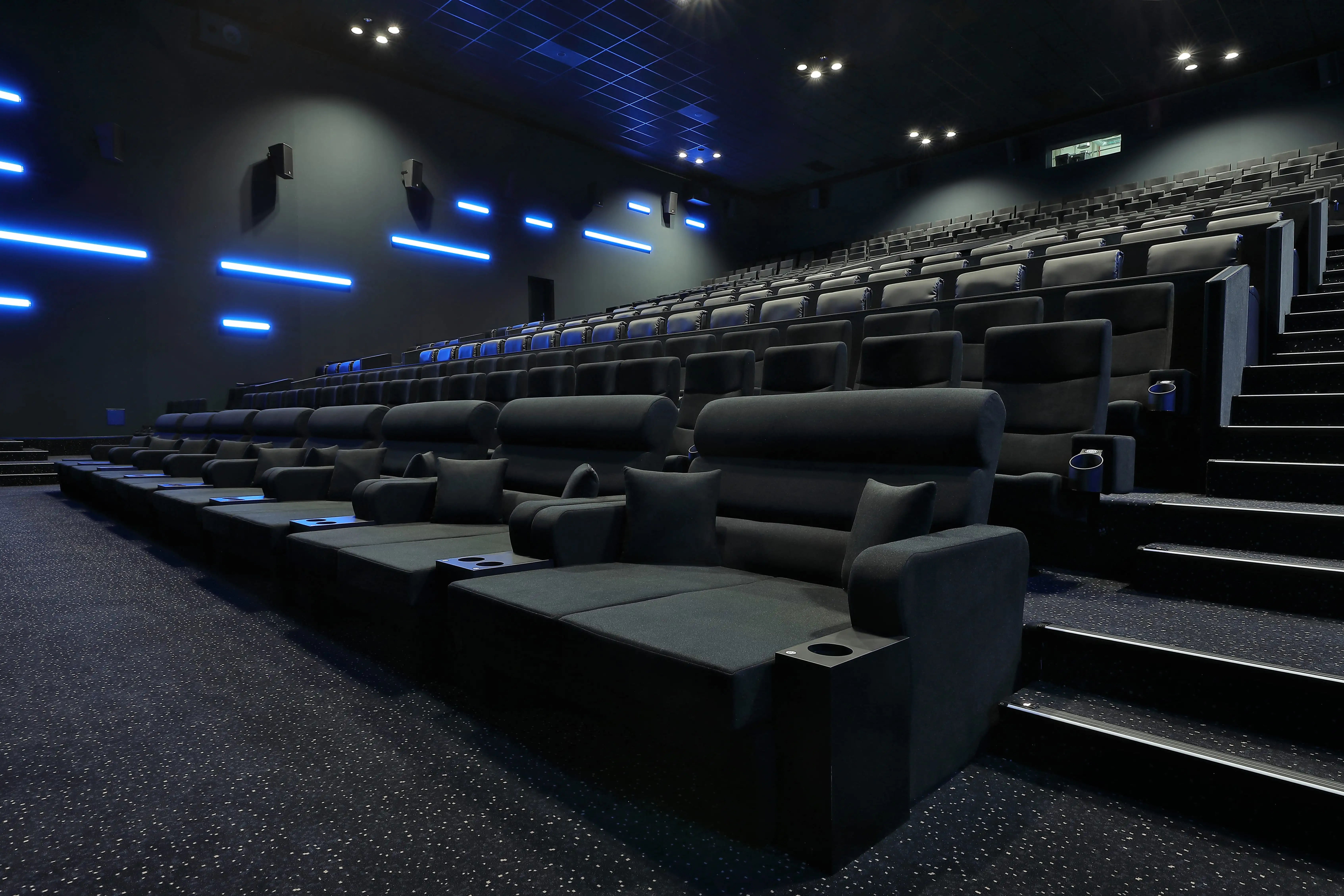 As a trusted manufacturer and supplier, we delivered high-quality cinema seating featuring built-in cup holders and fire-retardant fabric for this European theater project. Image