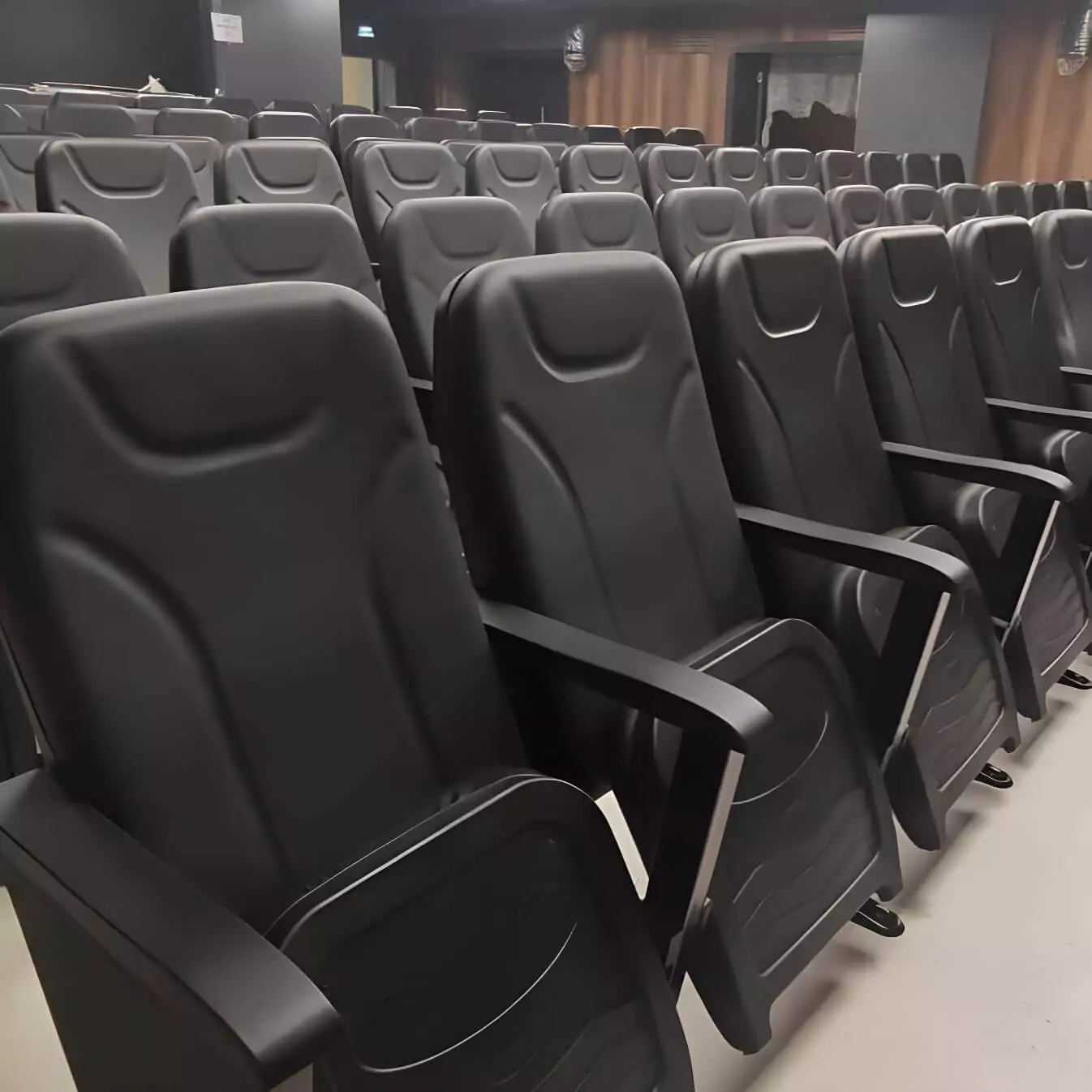 This theater seating project showcases our certified seating options, combining fire-retardant synthetic leather with sturdy wooden armrests, crafted for comfort and safety in auditorium and conference settings. Image