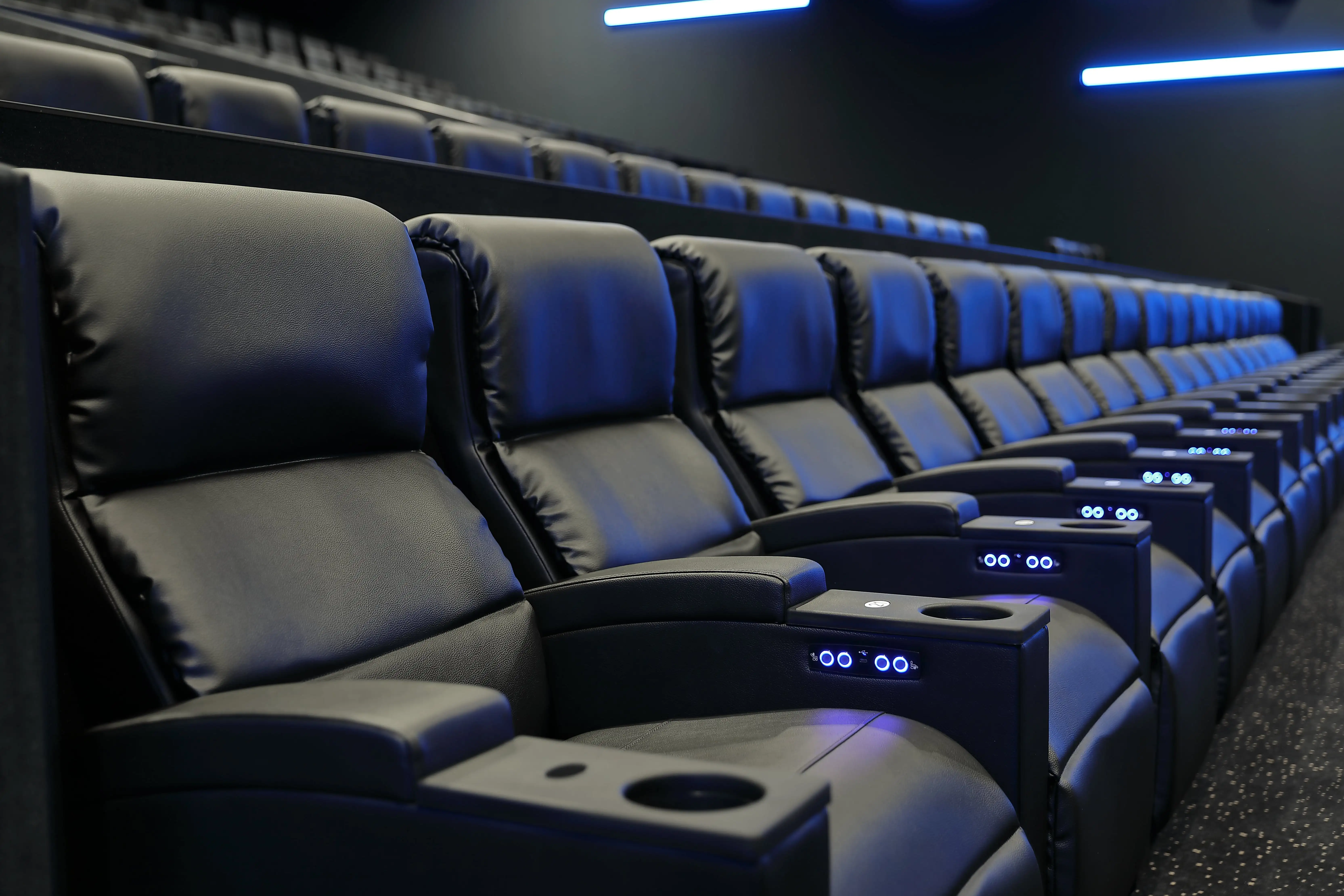 This cinema seating project features plush recliner chairs with dual motor systems and fire-retardant upholstery, providing both luxury and safety for European theaters. Image